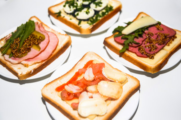 Four types of sandwiches with different ingredients for breakfast