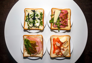 Four types of sandwiches with different ingredients for breakfast