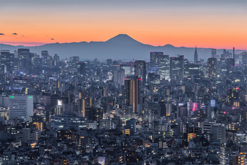 Tokyo night city view with Mountain Fuji. Mount Fuji lies about 100 kilometres south-west of Tokyo, and can be seen from there on a clear day.