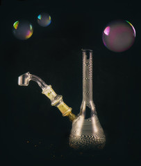 Dabbing glass rig with soap bubbles floating - isolated over bla