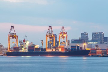 Fototapeta premium Cargo freight ship with stacked container at harbor terminal