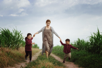 Image of Kids and mother running in the fields,them so happy joyful,Happy family concept