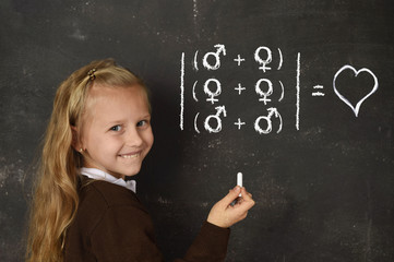 schoolgirl in uniform holding chalk writing on blackboard standing for freedom of sexuality orientation