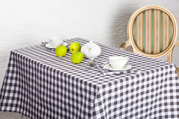 Beautiful decorated table with cutlery on the checkered tablecloth
