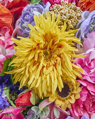 fake sunflower and roses closeup, colorful background