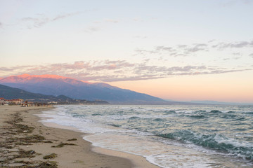 Bright dawn over Mediterranean Sea with long sand beach. Nei Pori village, Pieria, Greece.
