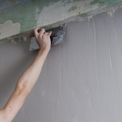 Hands Plasterer at work. Application of the plaster on the wall.