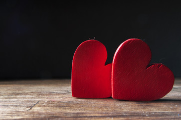 Two red wooden heart on a wooden background. Space for text