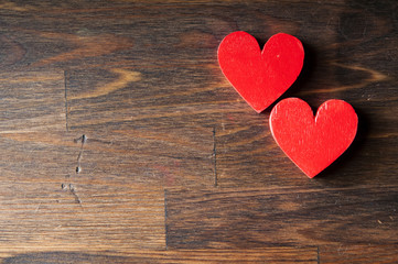 Two red wooden heart on a wooden background. Space for text