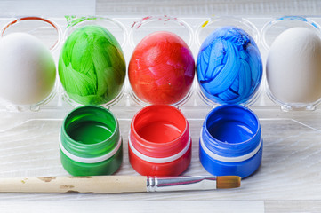 Eggs, paint and paint brush on the table. Preparation for Easter