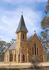 Fototapeta na wymiar DUNOLLY, VICTORIA, AUSTRALIA - October 4, 2015: St Mary's Catholic church, a Gothic Revival building made of local sandstone and granite, was opened in 1871. The steeple was added in 1980