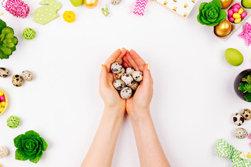 Woman holding quail eggs on spring decoration background. Easter concept.  Flat lay, top view