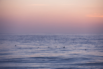 Fototapeta na wymiar Surfers waiting for their wave at sunrise