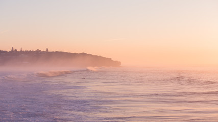 Surfers waiting for their wave at sunrise