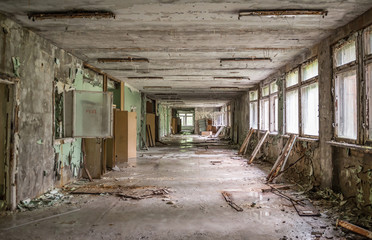 Fototapeta na wymiar gloomy school corridor with debris in Pripyat