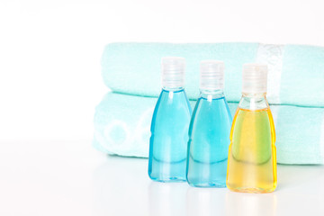 Obraz na płótnie Canvas Cosmetics bottles mock ups with shower gel, body moisturizing lotion or herbal shampoo and bath towels.