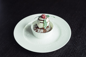 Cake chocolate Fondant with a scoop of ice cream on a white plate