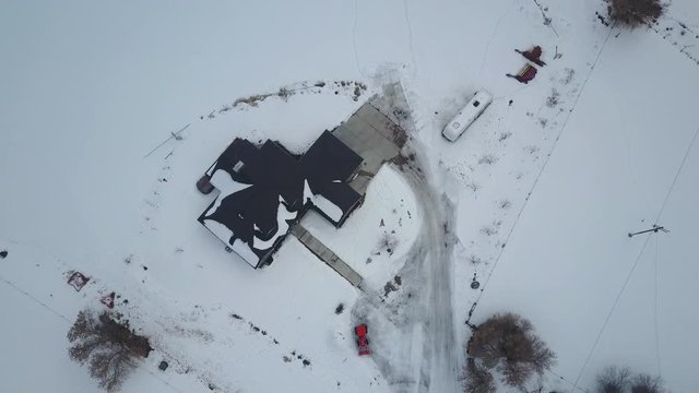 Aerial rural farm house winter snow. Aerial point of view. Winter storm blizzard white snow. Rural farm community. Hard seasonal weather. Hazard to driving. Surveillance spy.