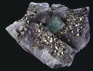 Emeraude brute sur calcite incrustée de pyrite