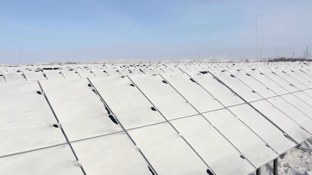snow-covered solar panels pan right