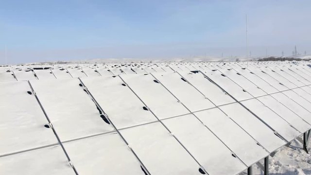 snow-covered solar panels pan left