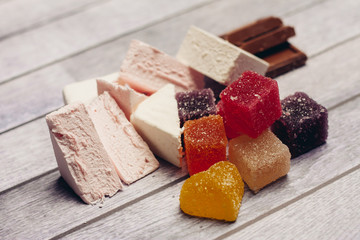 marshmallow, colorful marmalade and chocolate on a wooden table