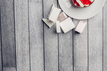 wooden background, white marshmallow, cake in a plate