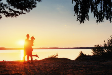 Fototapeta premium Romantic couple on the beach at colorful sunset background