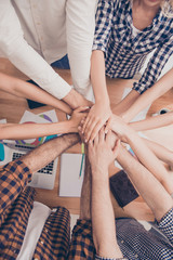 Close up of successful group of businesspeople putting hands tog