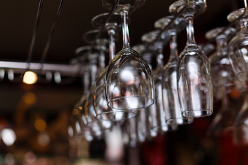 Fototapeta na wymiar different glasses hanging over the bar. Soft focus