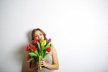 Young woman holding a bouquet of bright tulips. Concept of Inter