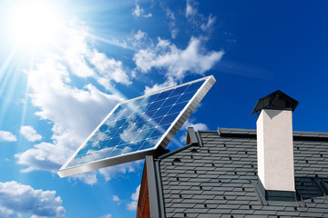 House roof with a solar panel on a blue sky with clouds and sun rays