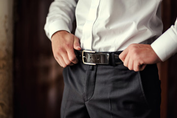 man putting on a belt, Businessman, Politician, man's style, male hands closeup, American...