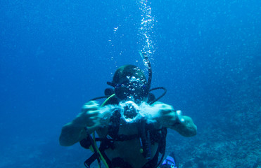 Scuba diving creating bubble ring underwater