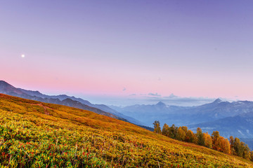 Magic autumn landscape and snow-capped mountain peaks. View of t