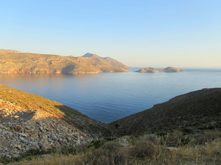 Naklejka premium The coast of Tilos island with blue sea and big stack at sunrise, Greece