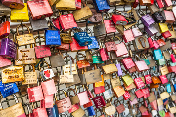 Fototapeta na wymiar Thousands of love locks which sweethearts lock to the Hohenzollern Bridge to symbolize their love in Koln, Germany