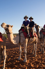 Couple sitting on camel in desert