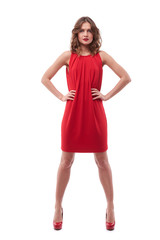 Confident young woman in red dress with hands on hips