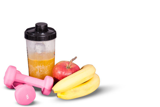 Fruity cocktail with fruit in a shaker. Small dumbbells for exercise and meter. Composition fitness drink and fruit on a white background.