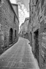A typical narrow alley in the historic center of Pitigliano, Grosseto, Tuscany, Italy, in black and white