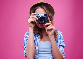 Young girl takes a photo with a retro silver camera