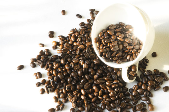 White cup with coffee grains on a white background