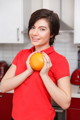 Brunette with orange in kitchen