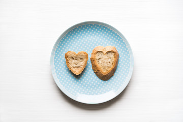 Heart-shaped bread on blue plate love concept
