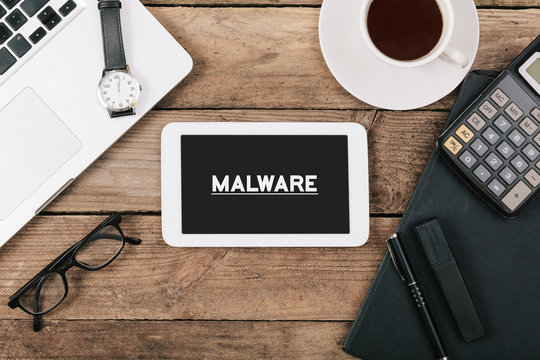 Text malware on screen of table computer at office desk