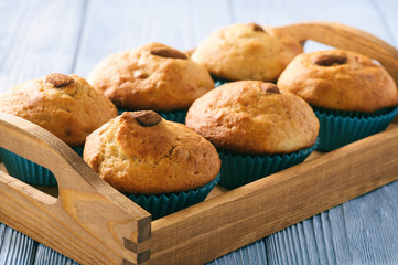 Sweet muffins with almond on blue wooden table.