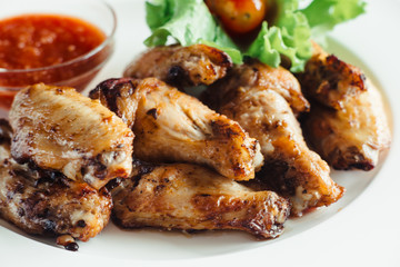 Chicken wings with sauce on plate on wooden table