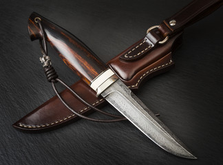 handmade knife Damascus of mosaic with a mammoth tusk on a black background