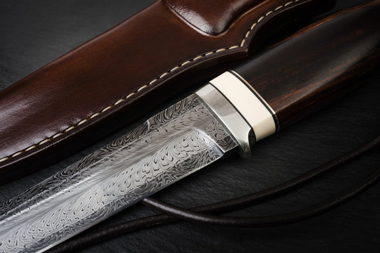 handmade knife Damascus of mosaic with a mammoth tusk on a black background